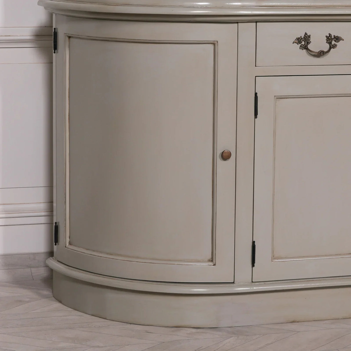 Cream painted wooden sideboard with curved corner door and metal handle on wood floor