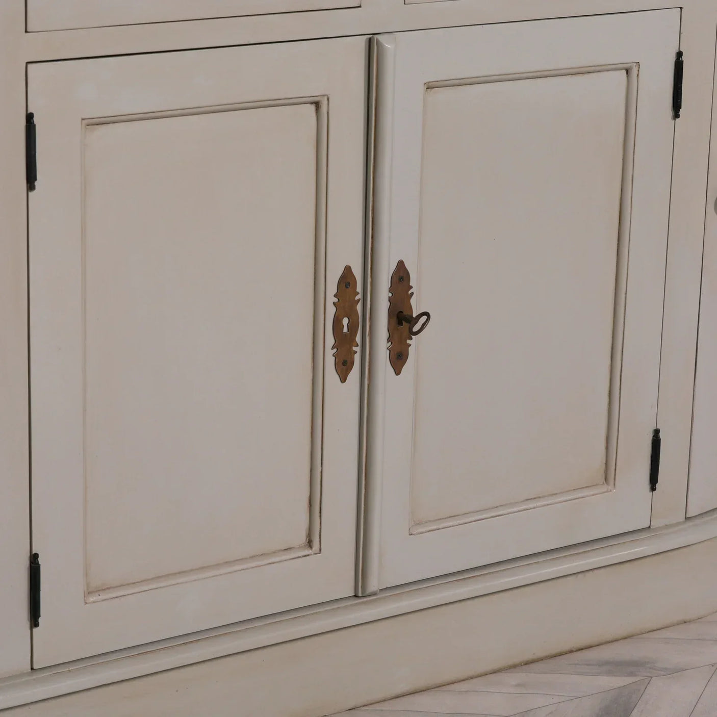 Cream wood sideboard cabinet doors with antique brass keyhole and lock detail