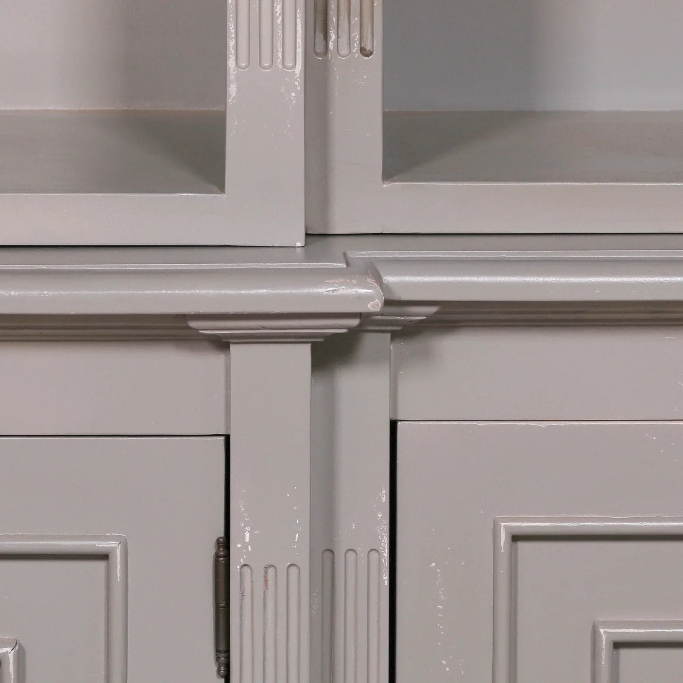 Closeup of grey painted cabinet doors with textured groove detailing and corner trim