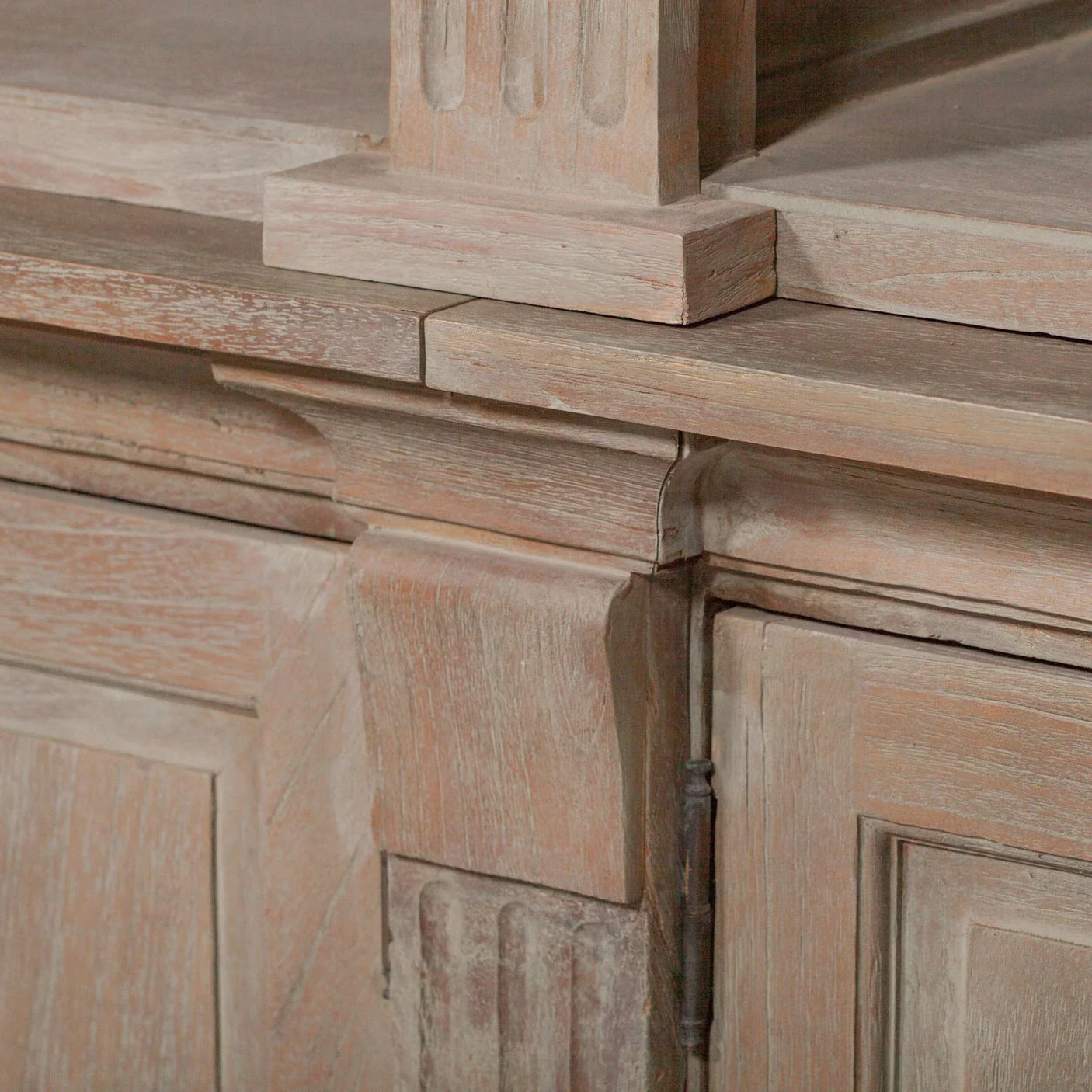 Closeup of rustic wooden sideboard corner showing carved detail and distressed finish