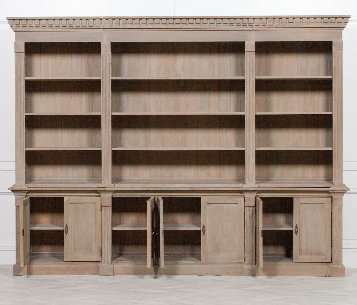 Large wooden bookcase with open shelving and four lower storage cupboards, two doors ajar