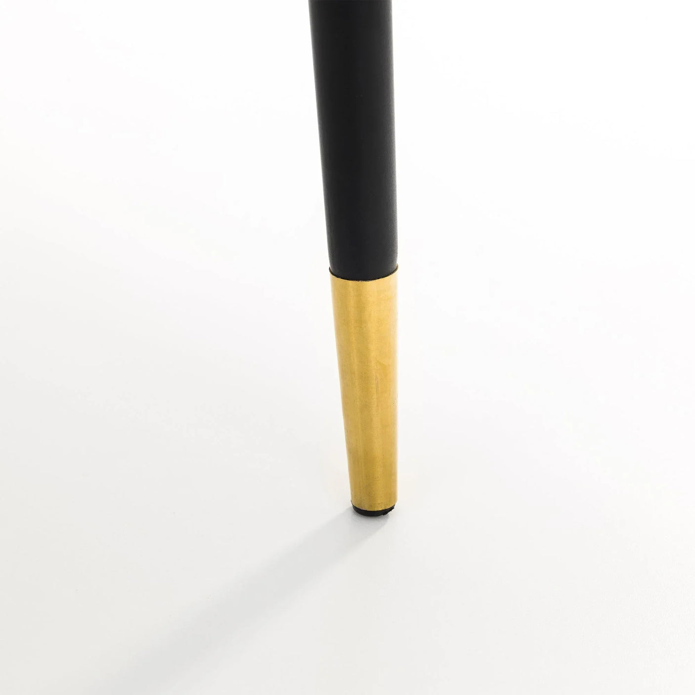 Dining chair leg with gold metal tip on white background