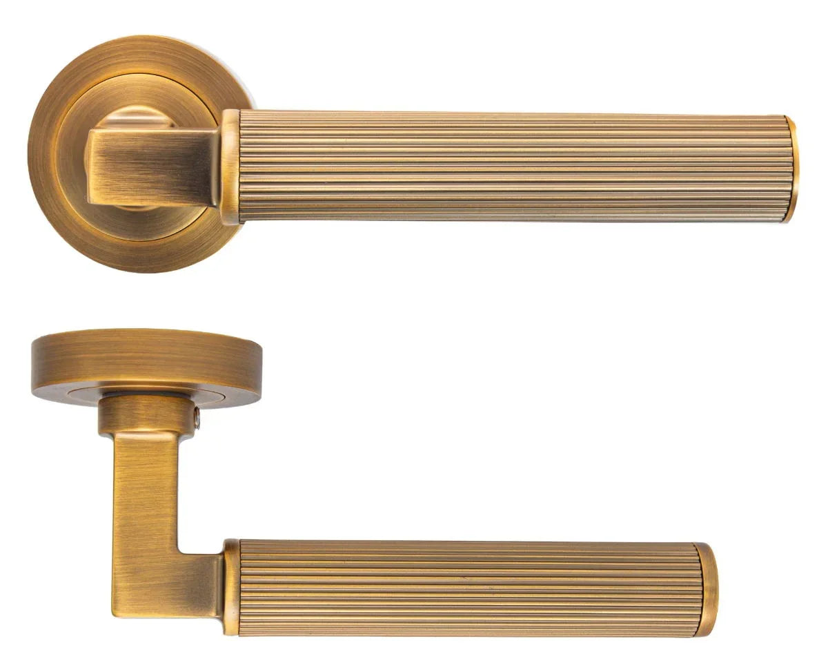Antique brass door handle with ribbed detail and round rose, front and side view