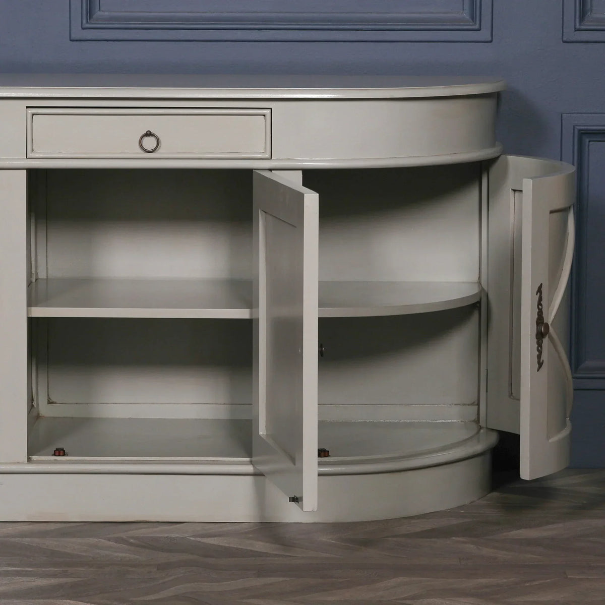 Grey sideboard cabinet with open doors showing shelves and storage space against blue wall