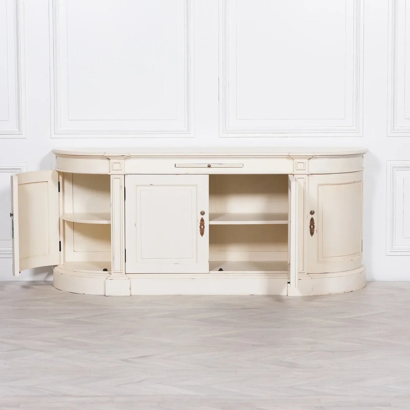 Cream wooden sideboard with open doors and shelves against a white panel wall