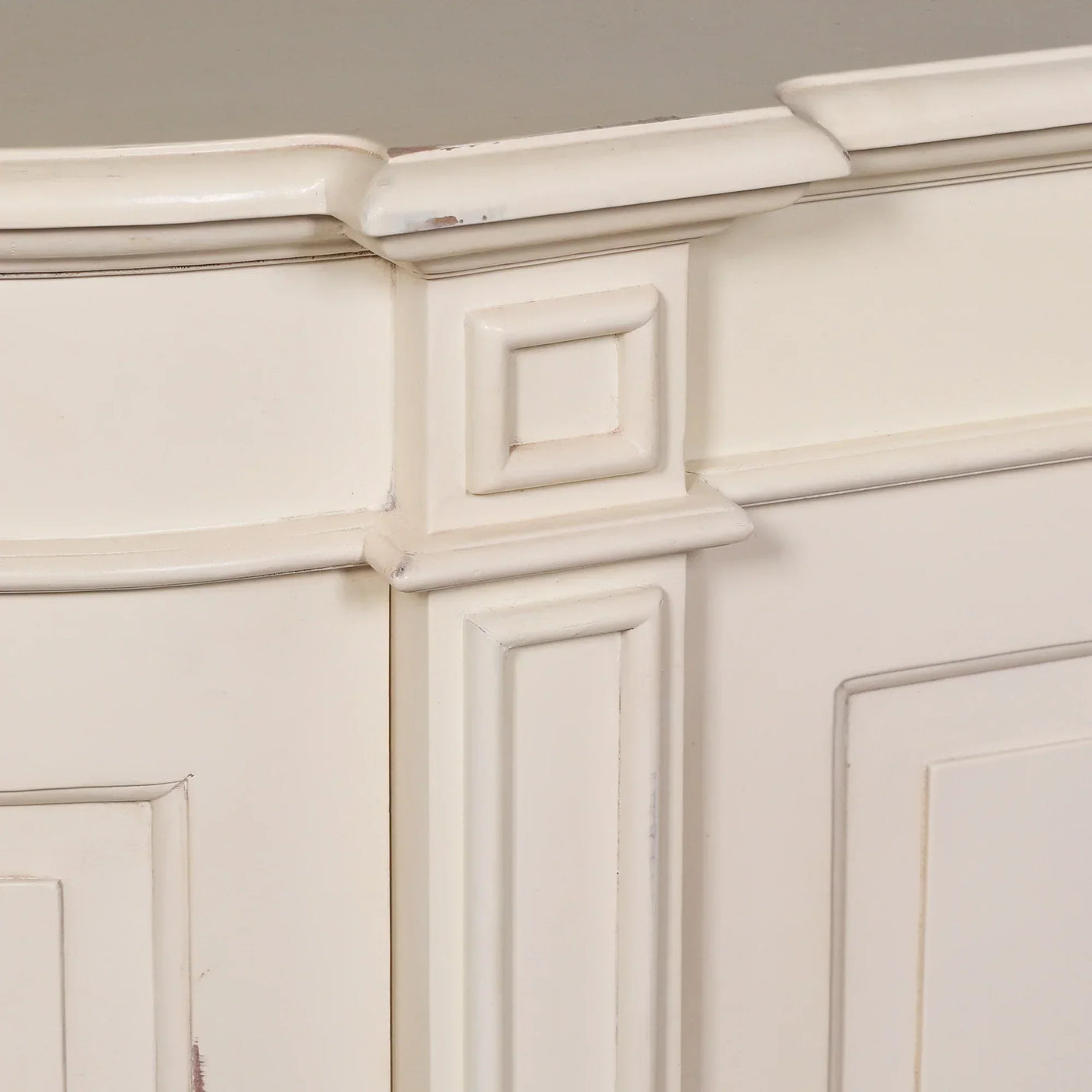 Cream painted wooden sideboard corner with decorative panel detailing