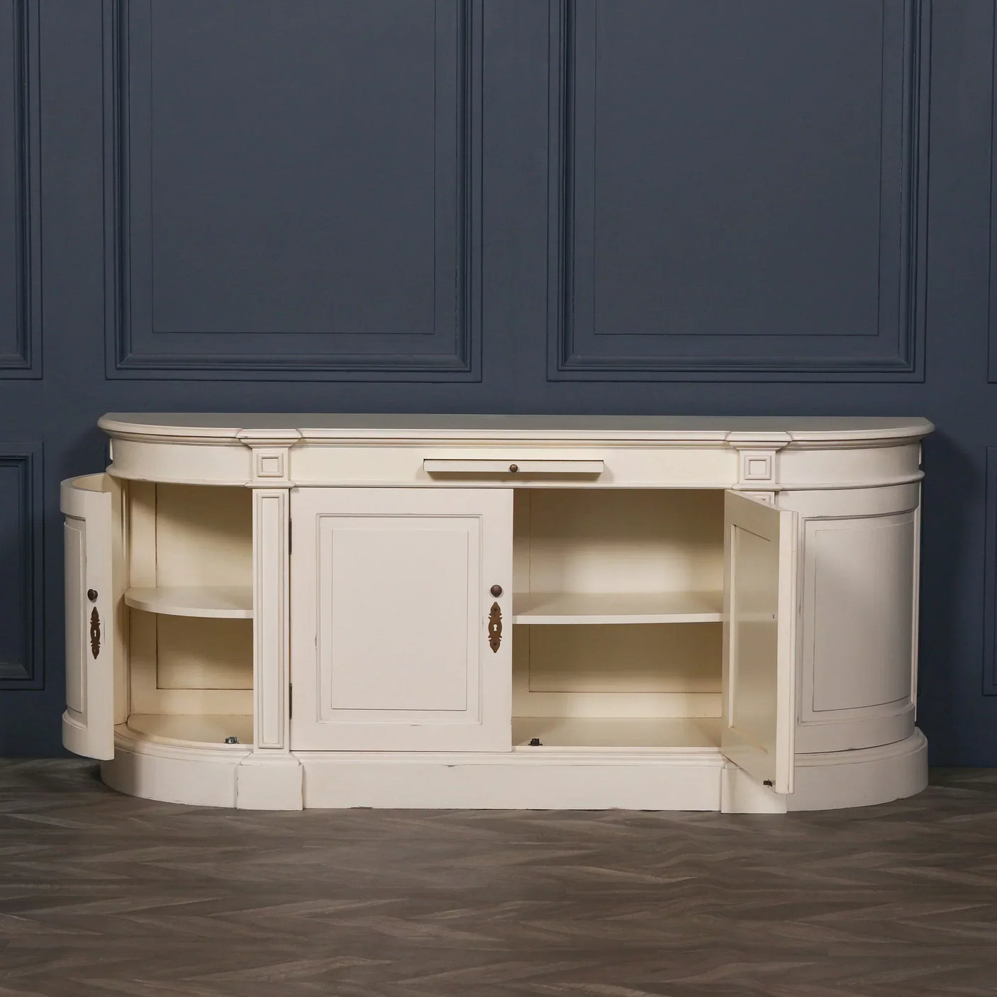 Cream wooden sideboard with open cabinet doors and shelves against blue paneled wall