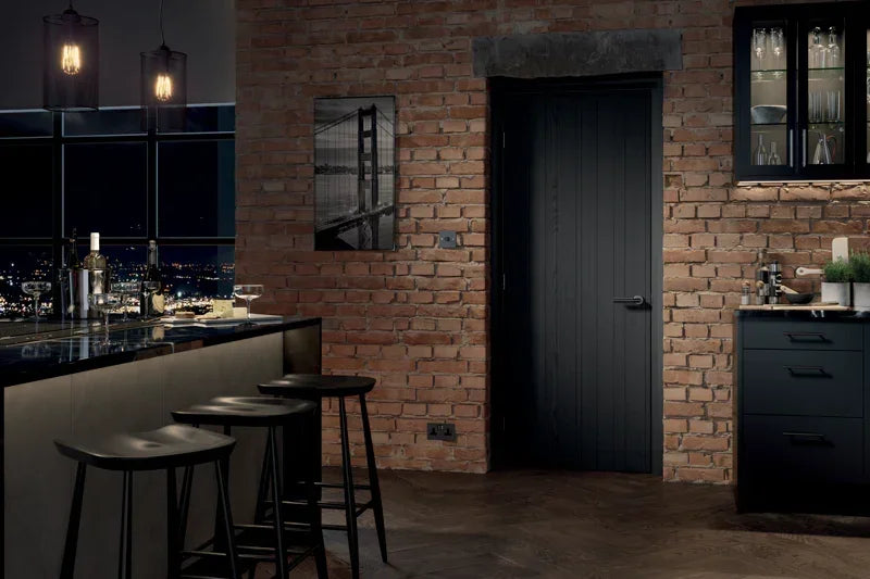 Dark charcoal internal door with vertical panels in a modern brick kitchen setting