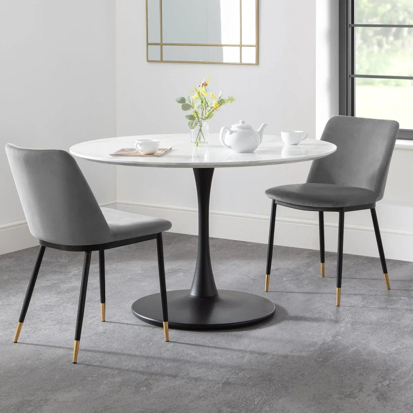 Grey velvet dining chairs with gold tips and white marble round table in modern dining room