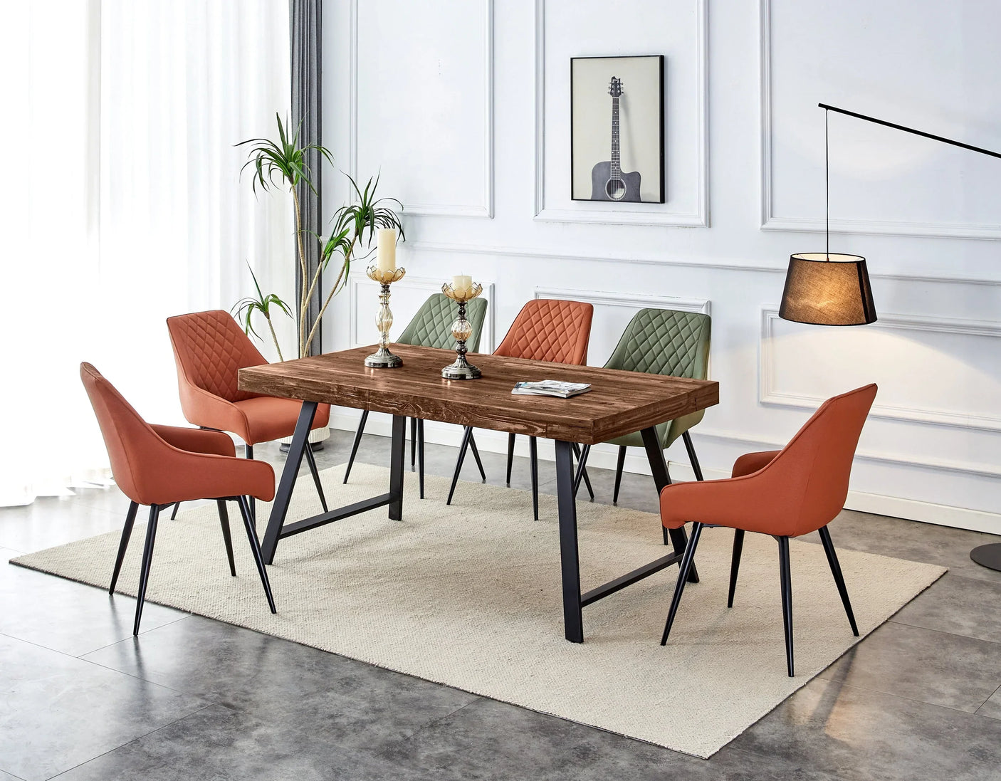 Wood dining table with black metal legs, orange and green upholstered chairs, modern room