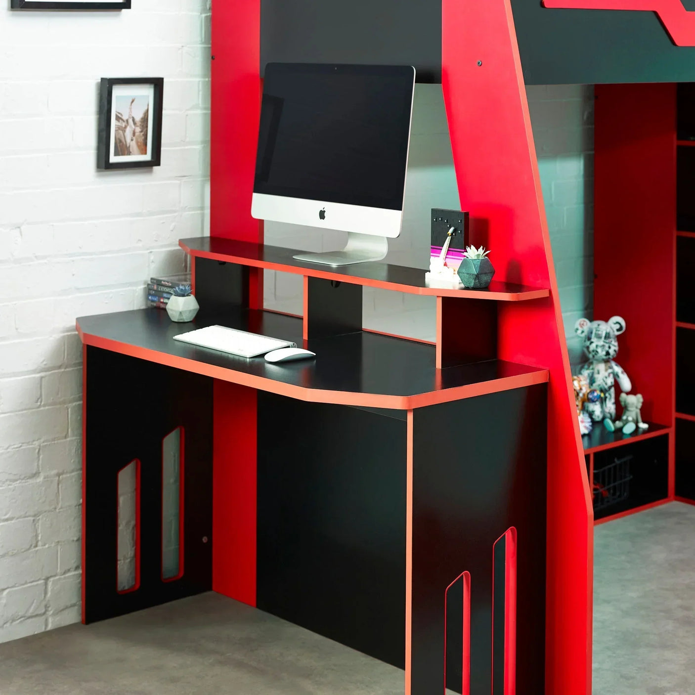 Black and red gaming desk with shelves, computer setup and accessories in bedroom