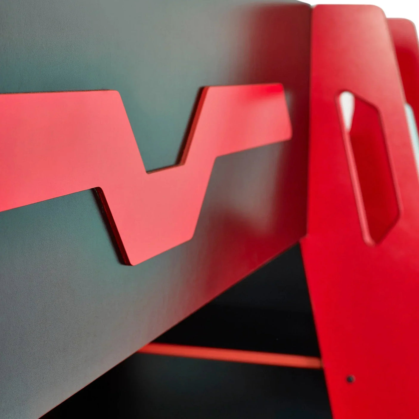 Red and black kids bunk bed with zigzag detail on side panel, close-up view