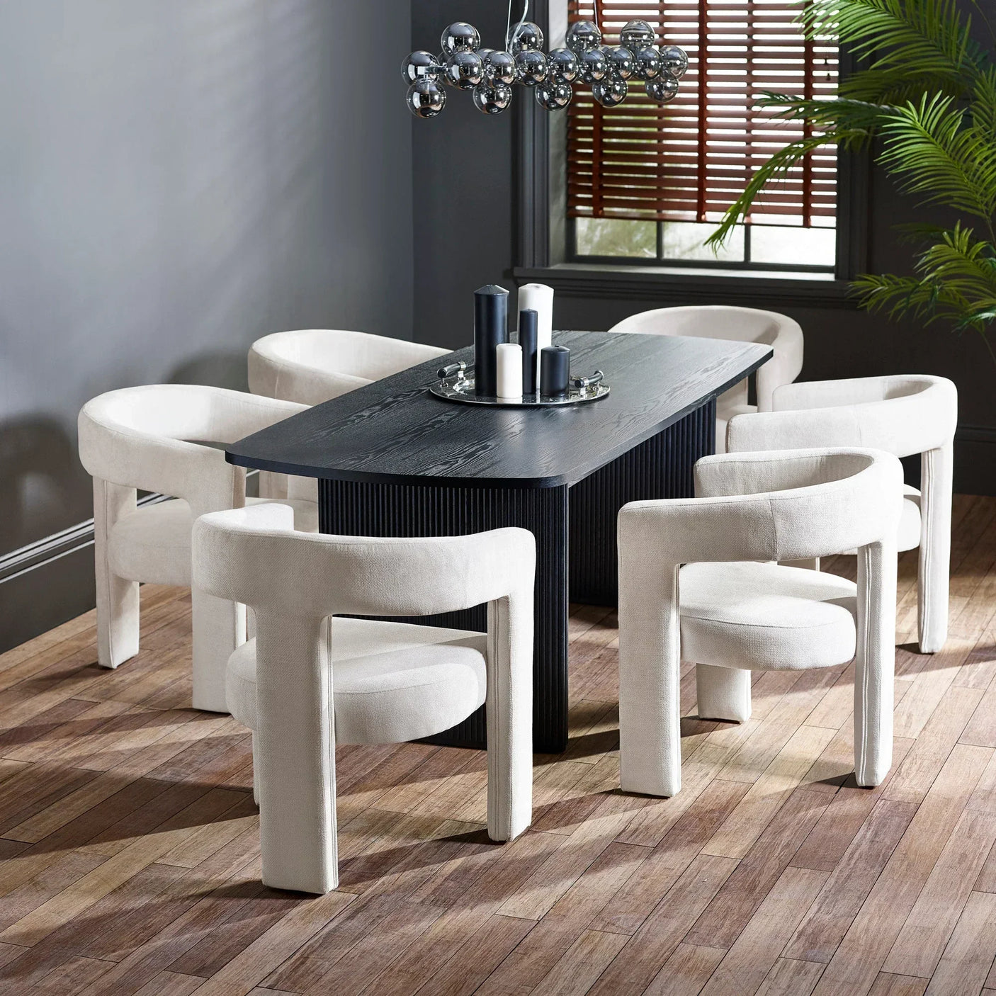 Modern dining set with black wood table and six cream upholstered chairs on wood floor