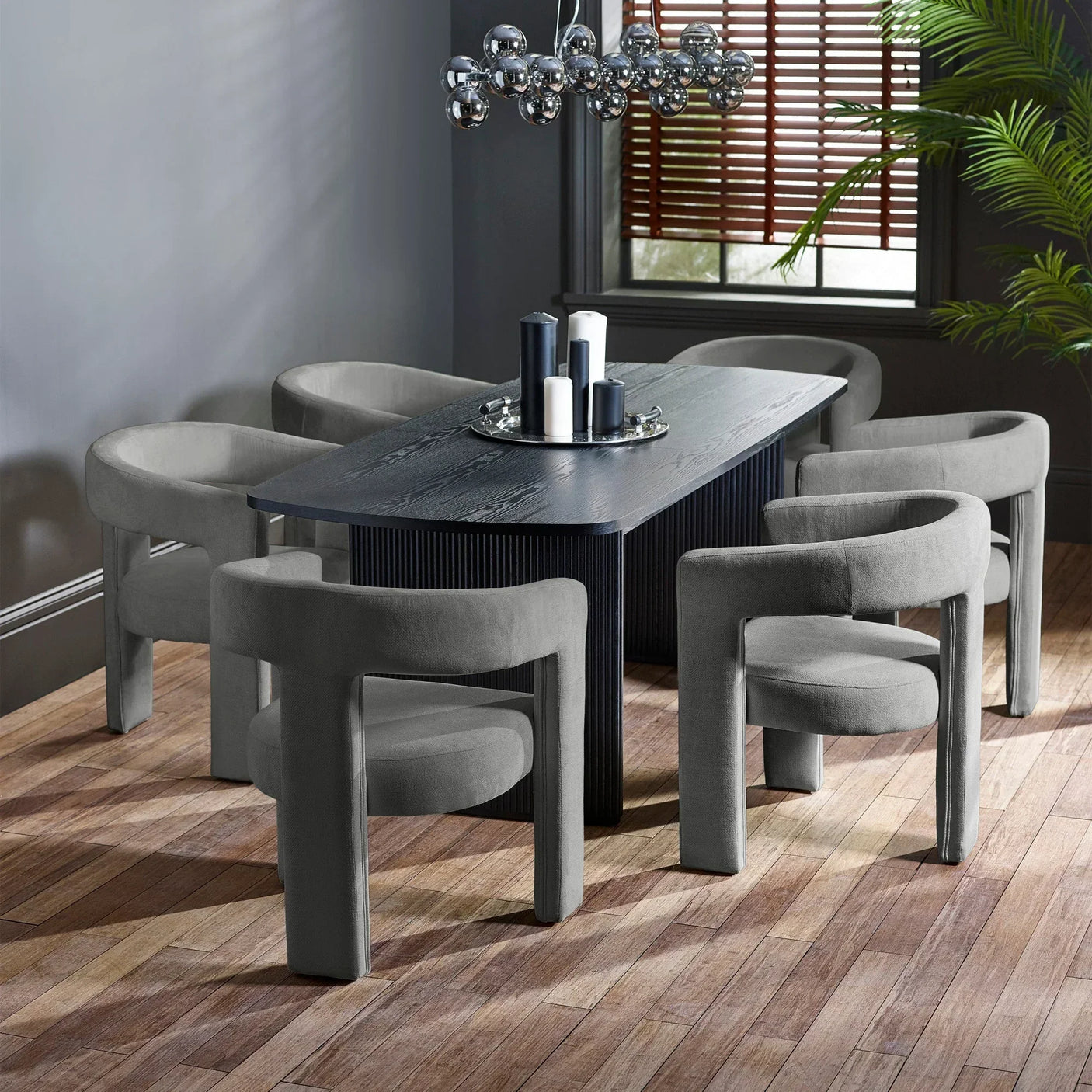 Modern dining table set with six grey velvet chairs and dark wood table in contemporary room