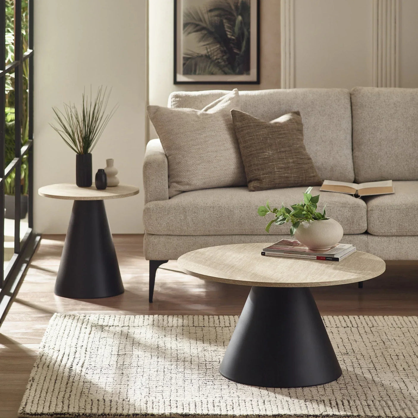 Round wooden coffee table with black metal base in modern living room setting