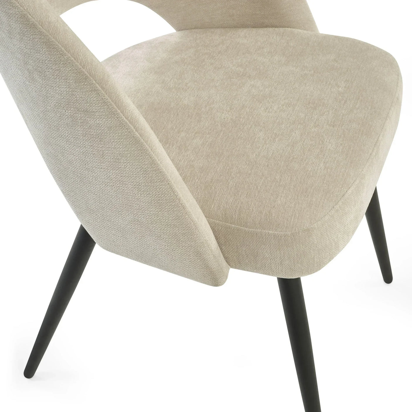 Beige upholstered dining chair with black angled legs, close-up on seat and backrest