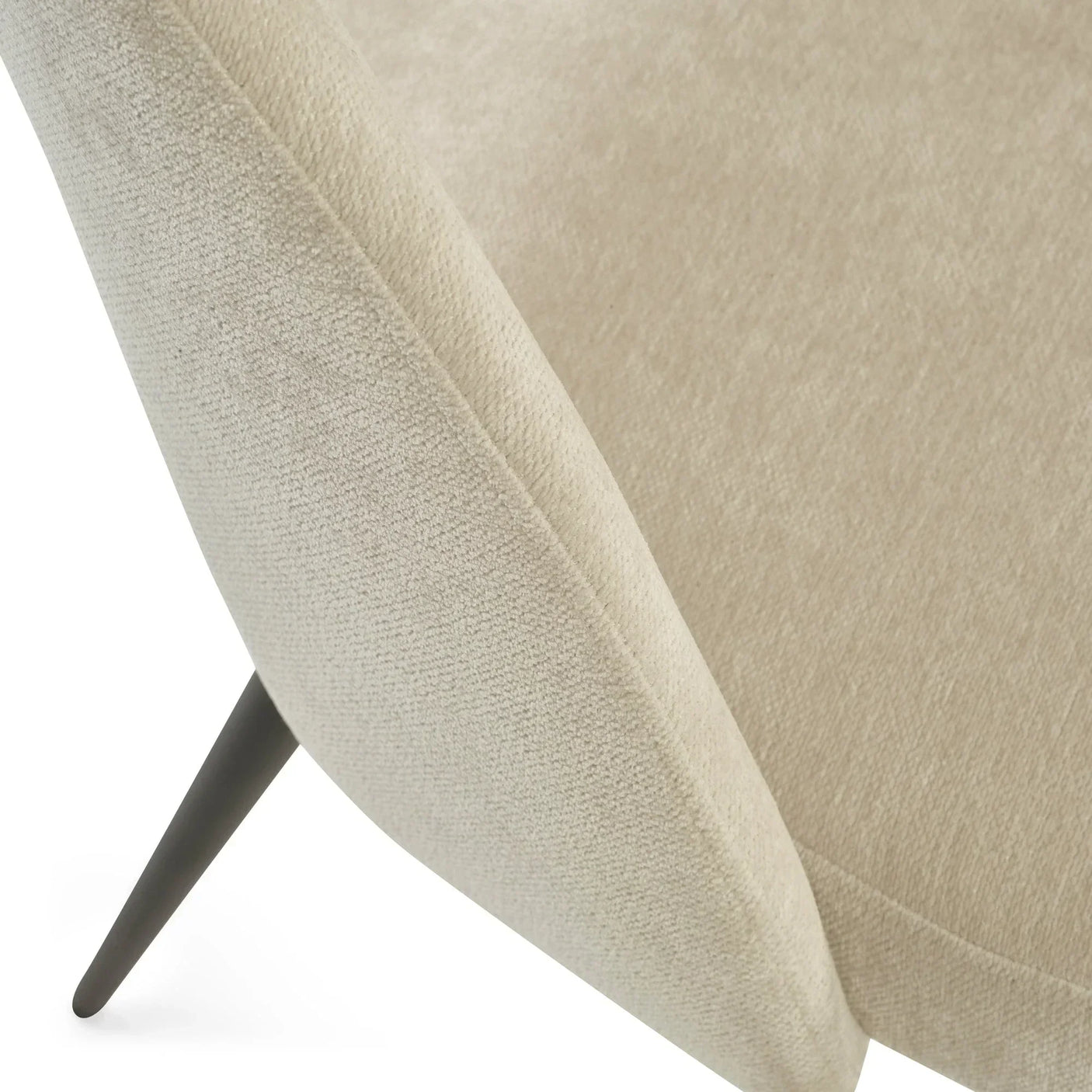 Beige fabric armchair with angled black metal leg, close-up of textured upholstery