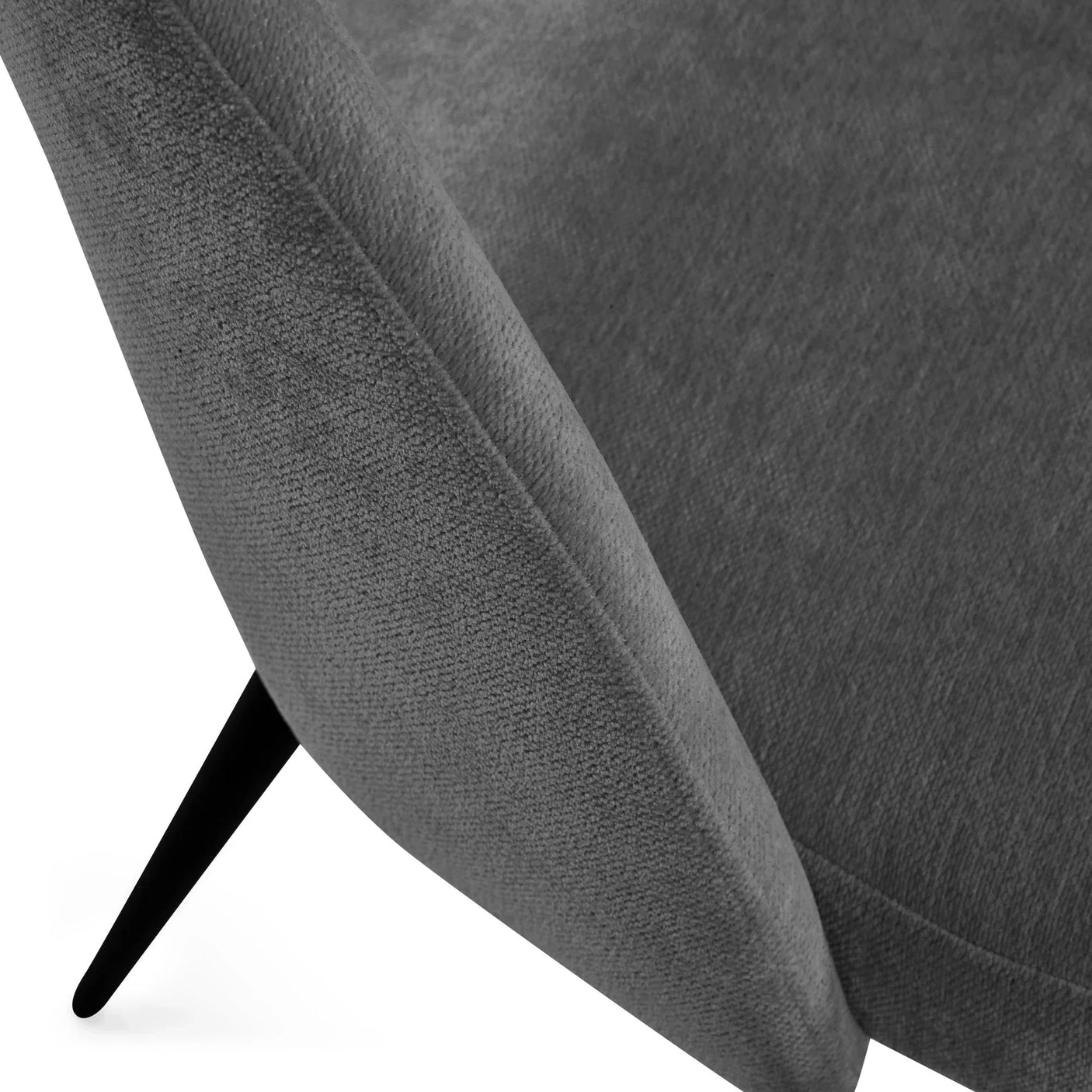 Closeup of grey fabric accent chair with angled black metal leg