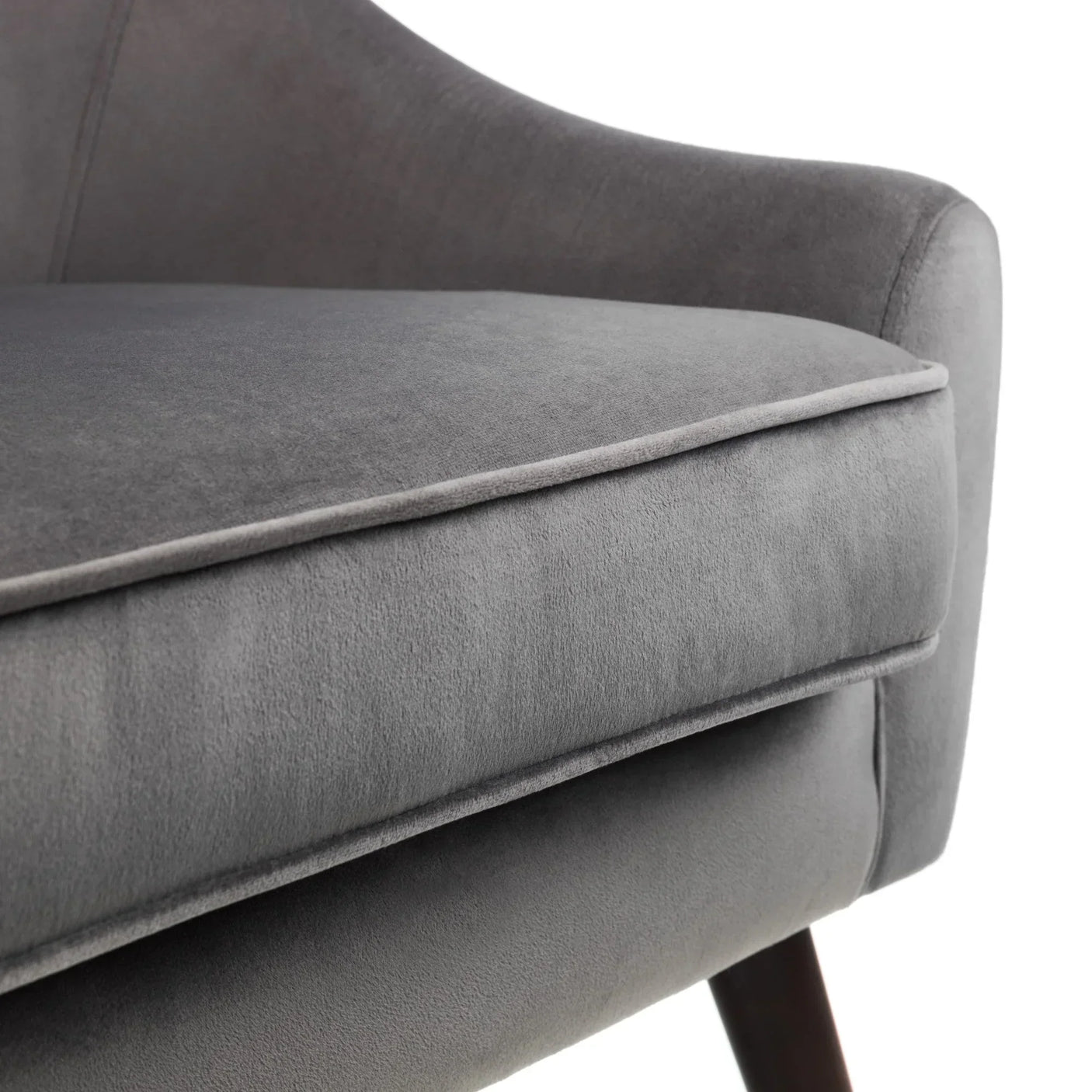 Close-up of grey velvet armchair cushion and seat with angled wooden leg