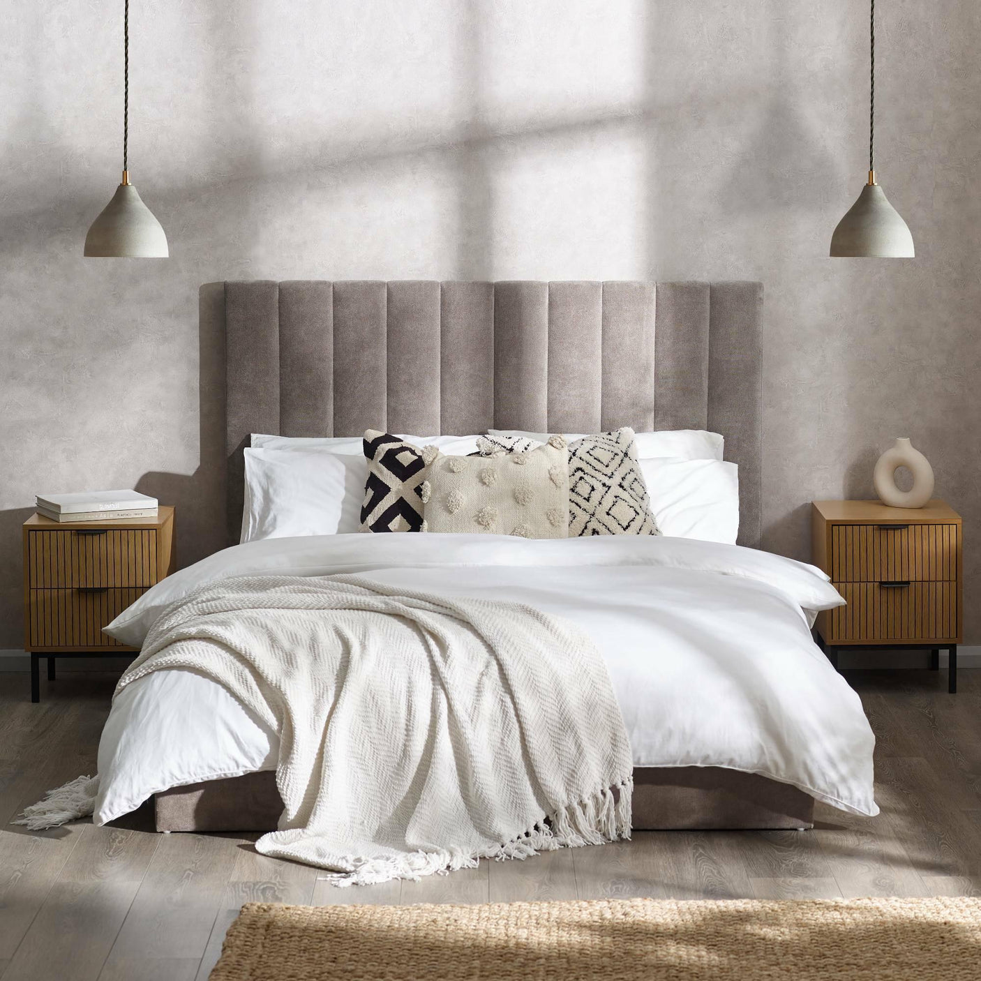 Grey double bed with vertical panel headboard, white bedding, and throw in modern bedroom