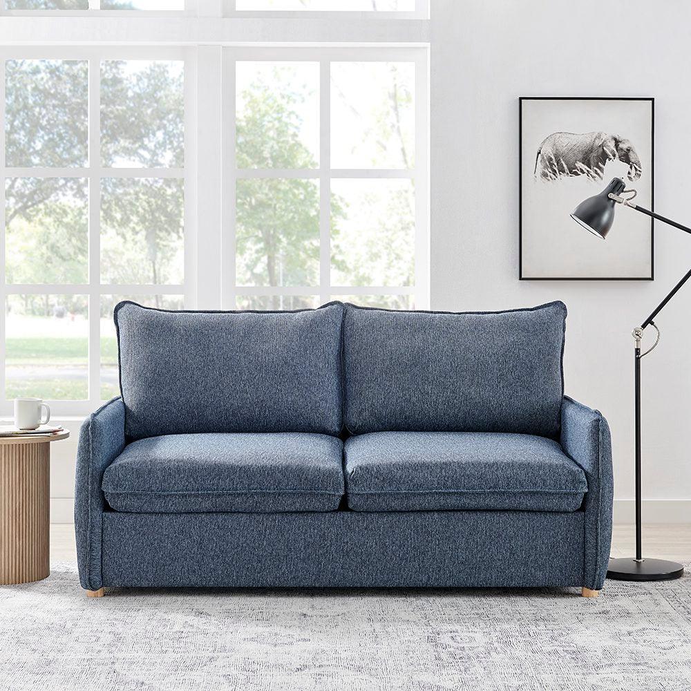 Blue fabric sofa with plush cushions in a bright living room, next to side table and floor lamp