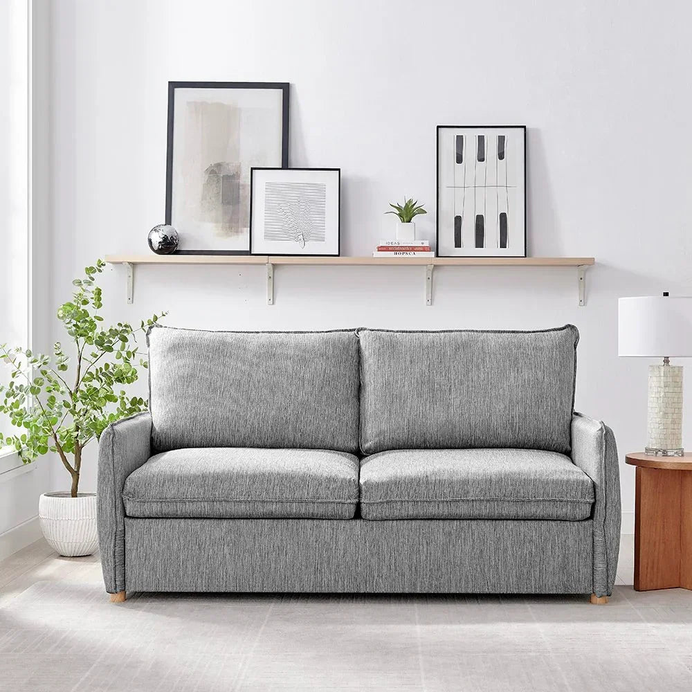 Grey fabric sofa with deep cushions in modern living room, plant and shelf decor behind