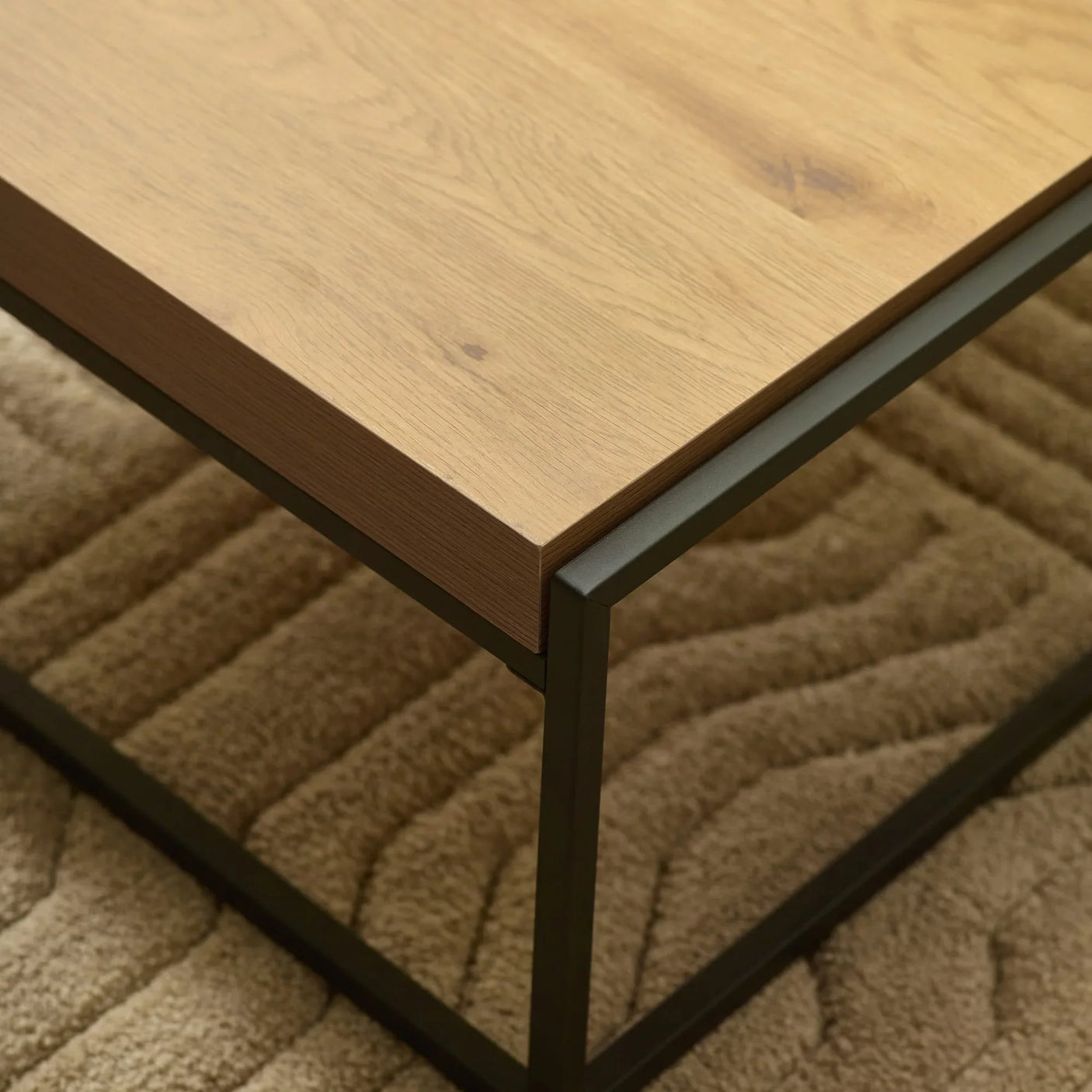 Oak wood coffee table with black metal frame on textured beige carpet
