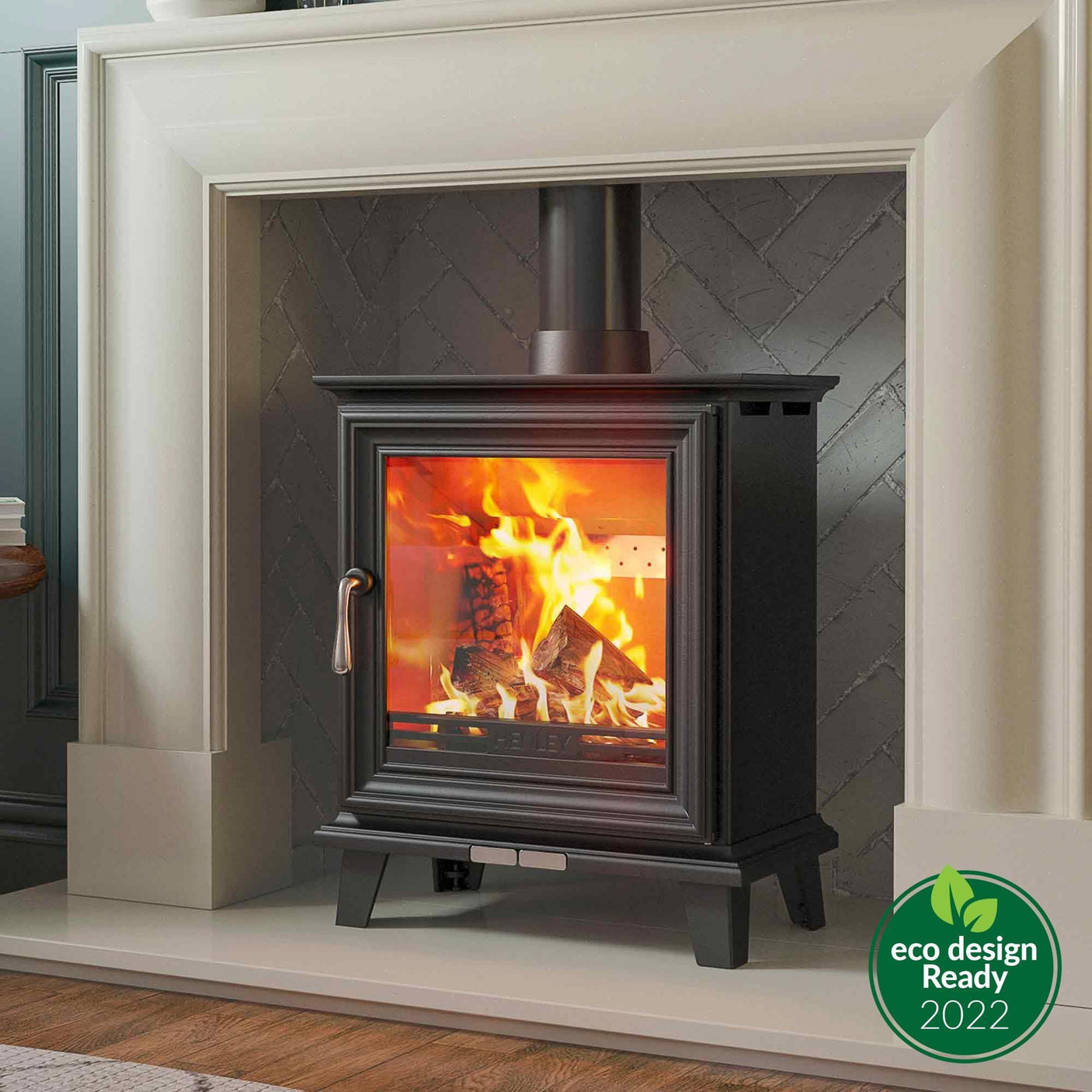Black wood burning stove with glass door in modern fireplace setting, eco design ready