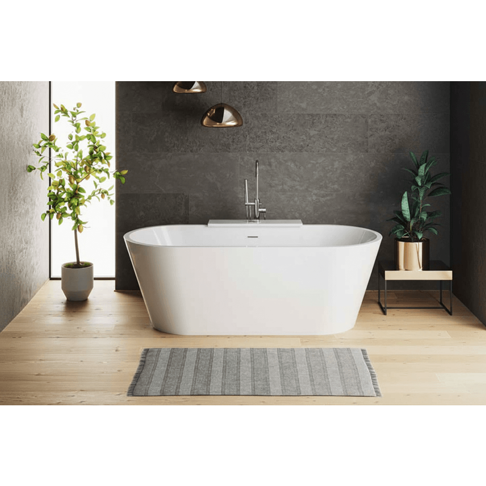 Modern bathroom with a freestanding bathtub, plants, and a gray wall.
