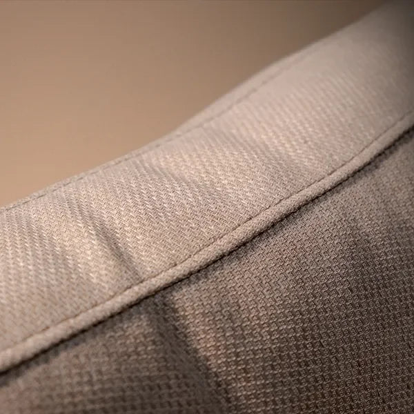 Closeup of sofa backrest showing textured light beige fabric and stitching detail