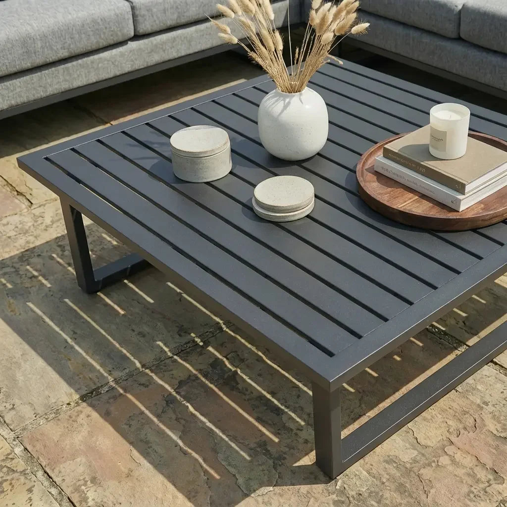 Zinc corner group sofa with grey cushions and metal slatted outdoor coffee table on patio