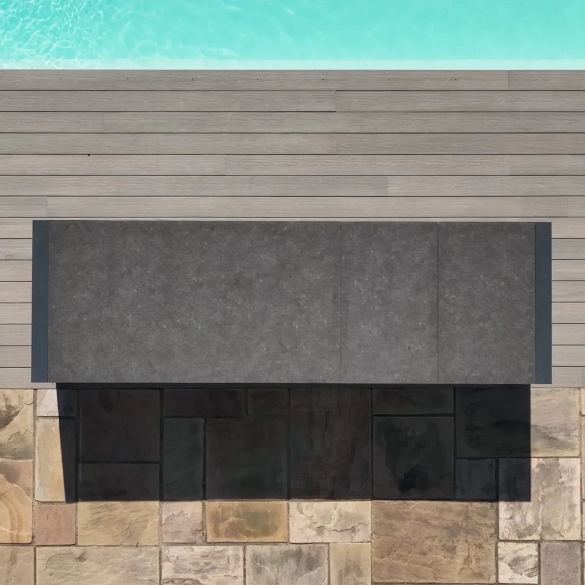 Rectangular outdoor dining table with dark stone-effect top on patio near swimming pool