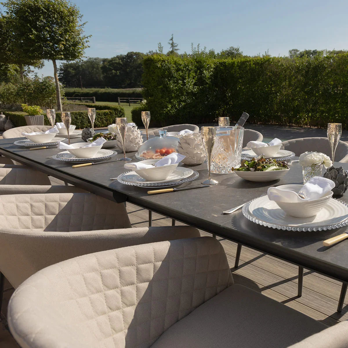 Outdoor dining set with quilted beige chairs and table set for six on patio