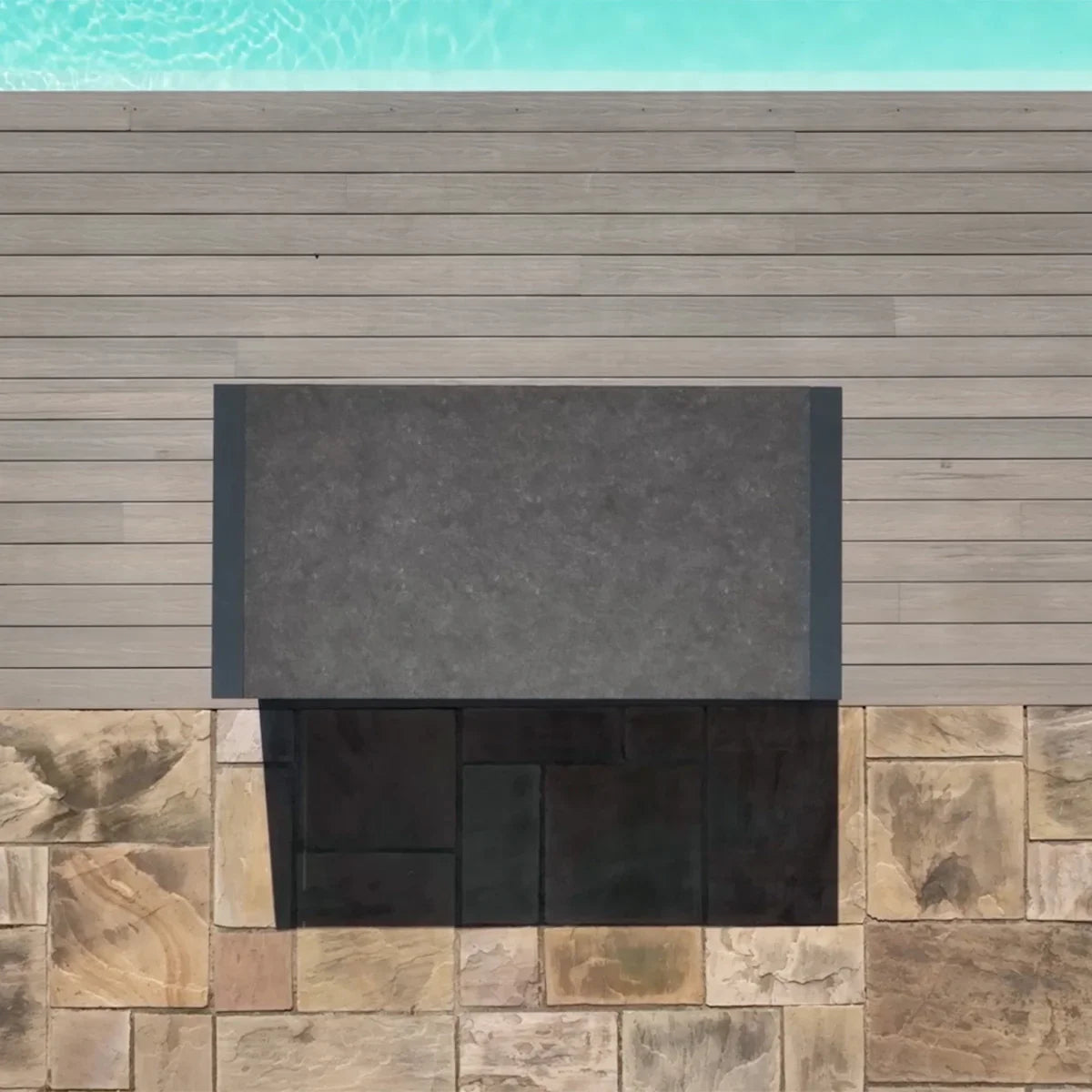 Rectangular outdoor coffee table with dark stone top on patio beside pool