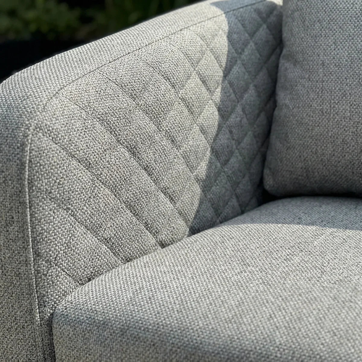 Grey fabric sofa with quilted backrest and textured seat cushion detail