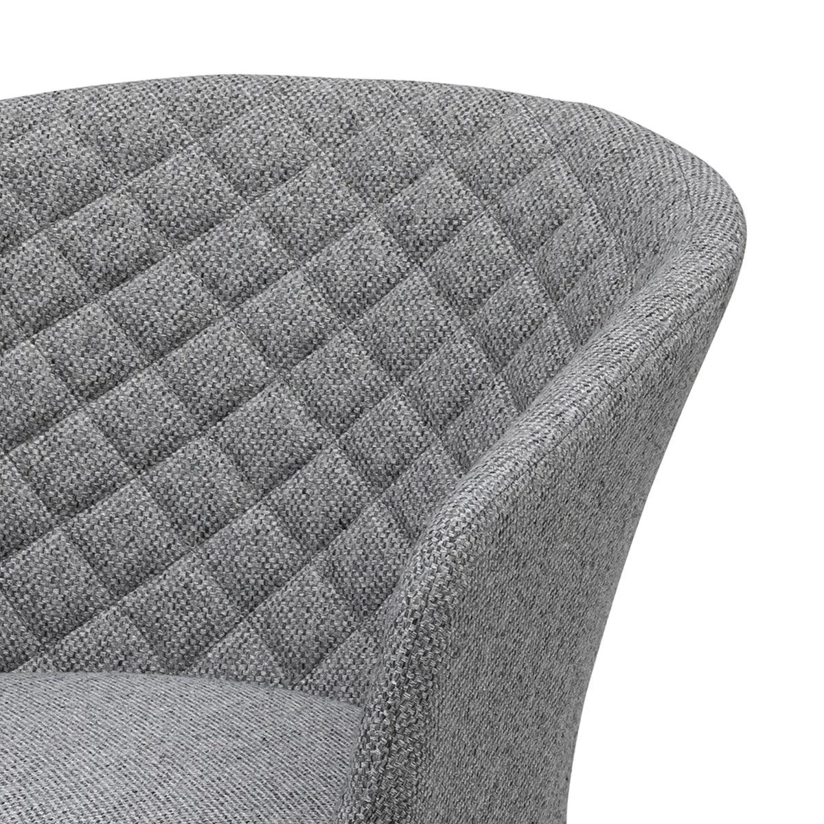 Grey fabric armchair with quilted backrest and curved arm detail