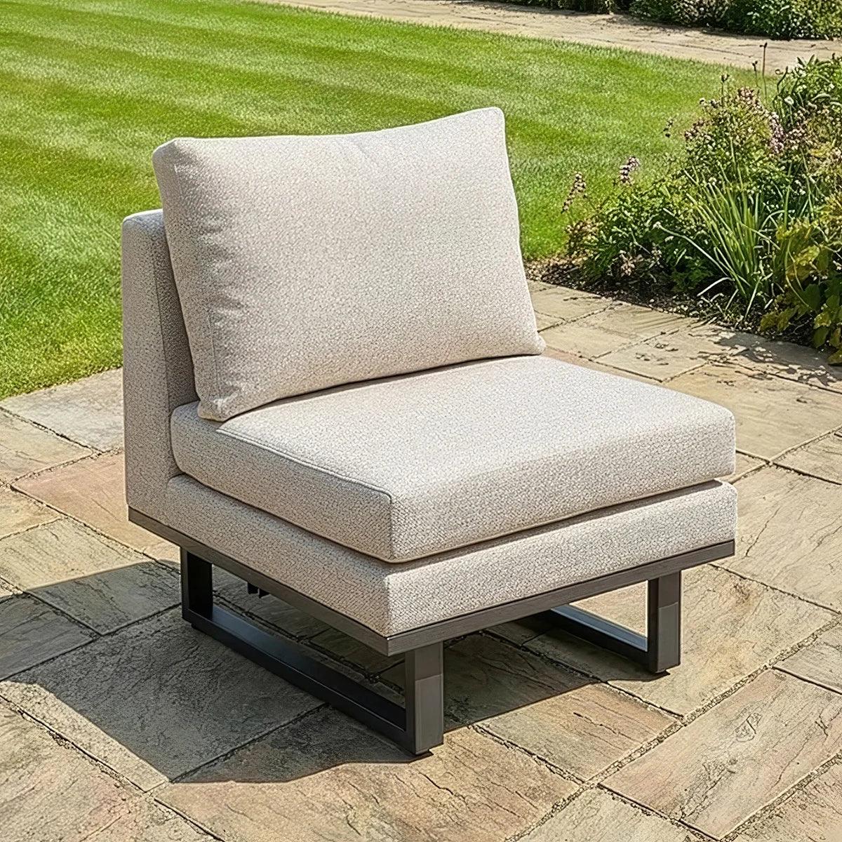 Beige outdoor garden corner chair with thick cushions on stone patio