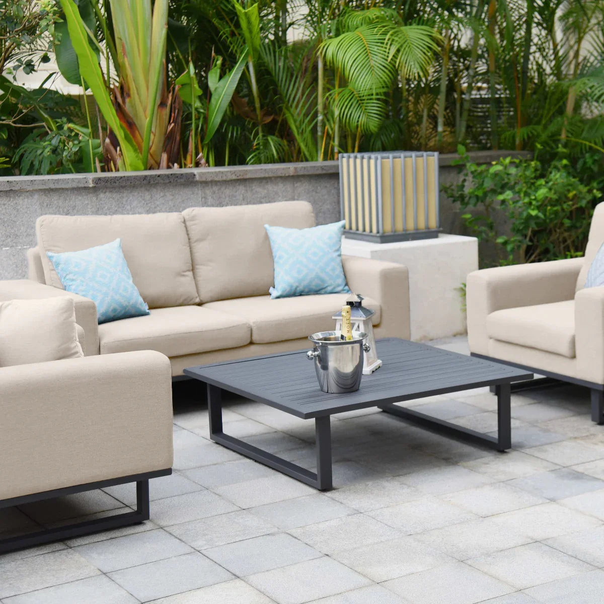 Beige outdoor sofa set with blue cushions and black coffee table on patio