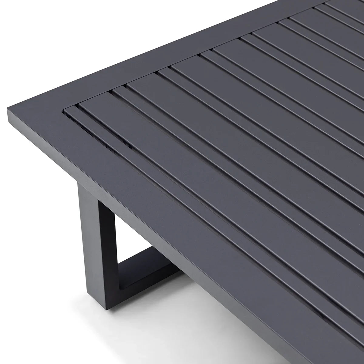 Dark grey slatted metal coffee table corner with modern square leg design