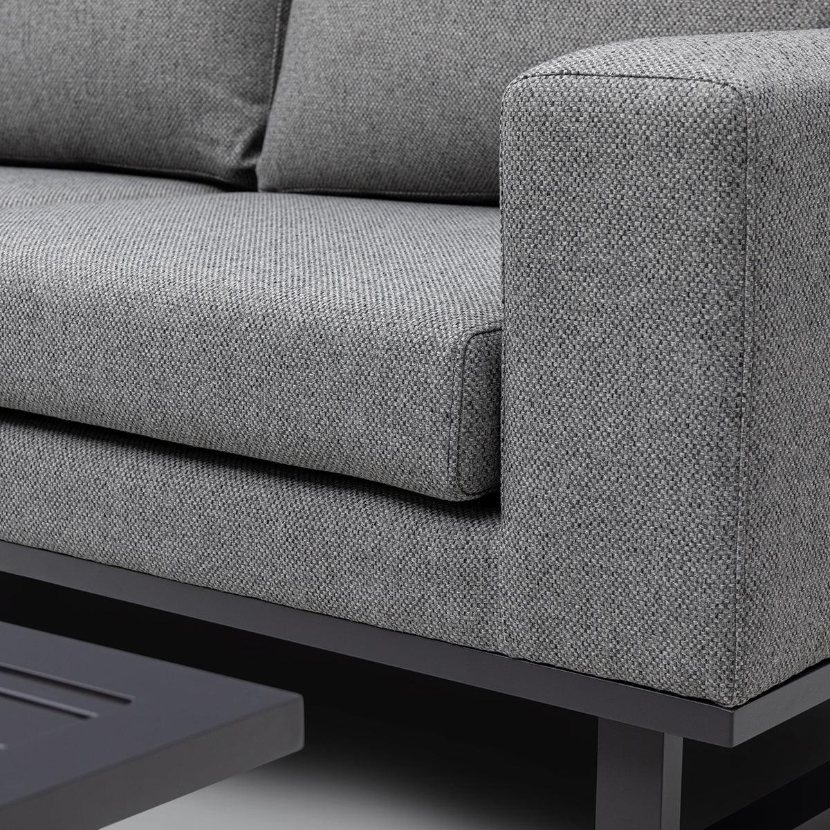 Close-up of grey fabric sofa arm and cushion with black metal frame