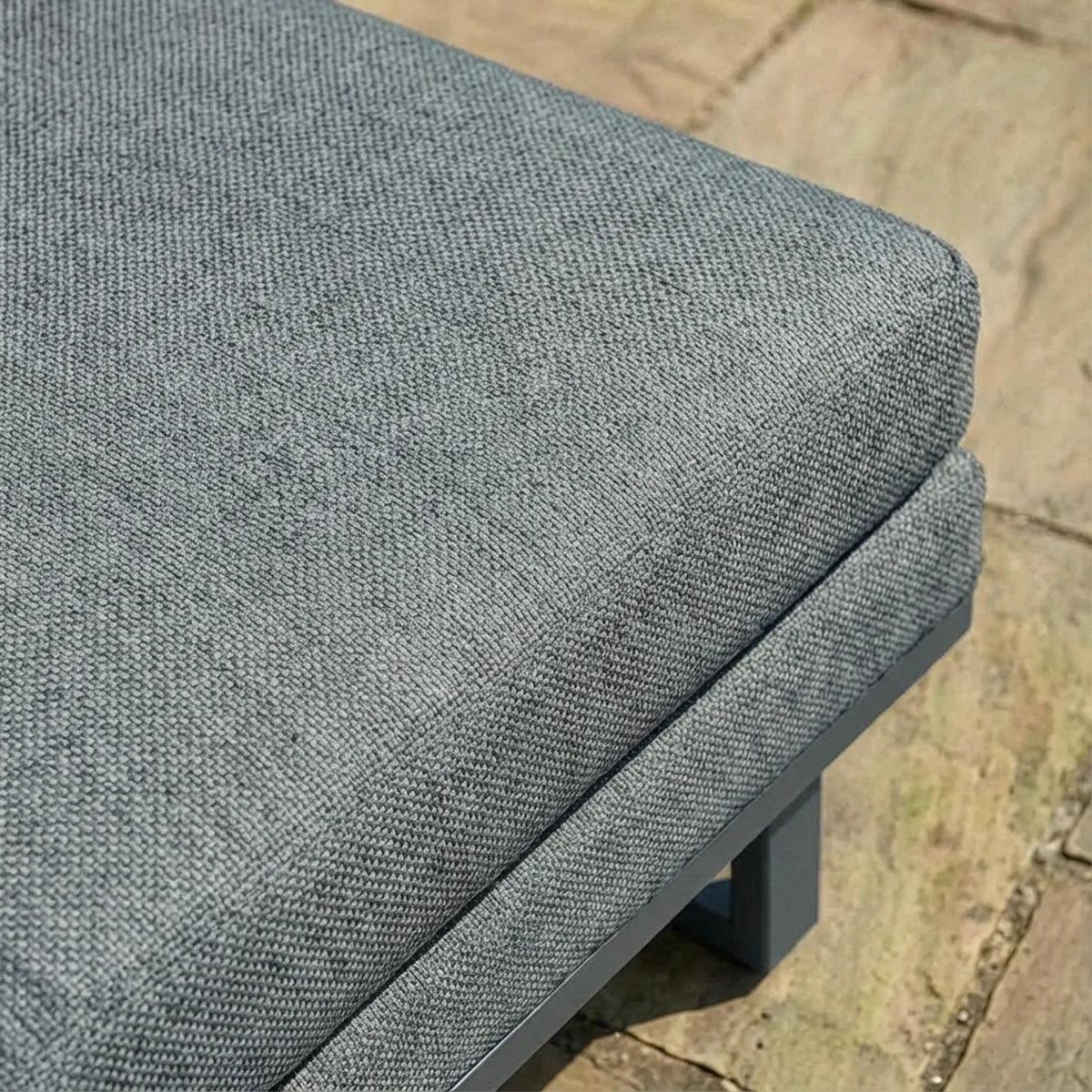 Close up of grey fabric outdoor sofa cushion on metal frame patio base