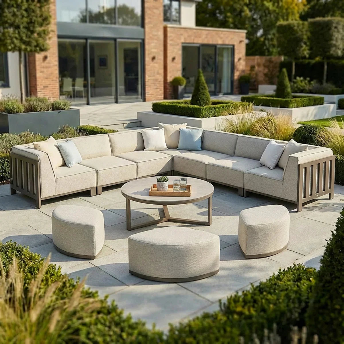Beige outdoor corner sofa set with round coffee table and stools on modern patio