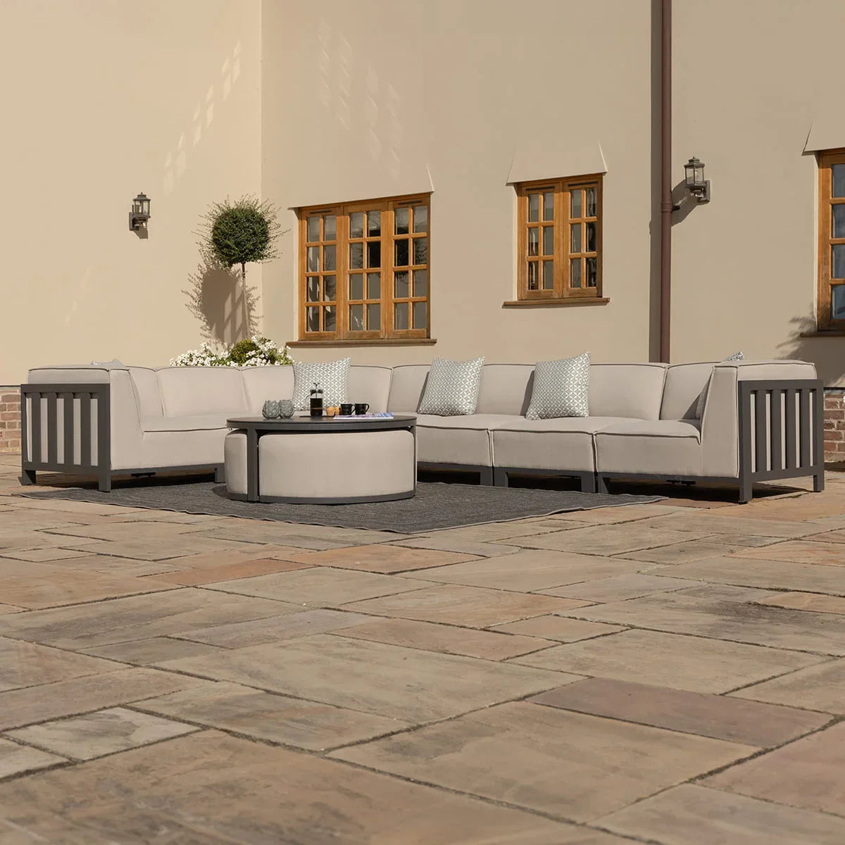 Beige outdoor corner sofa set with round coffee table on patio