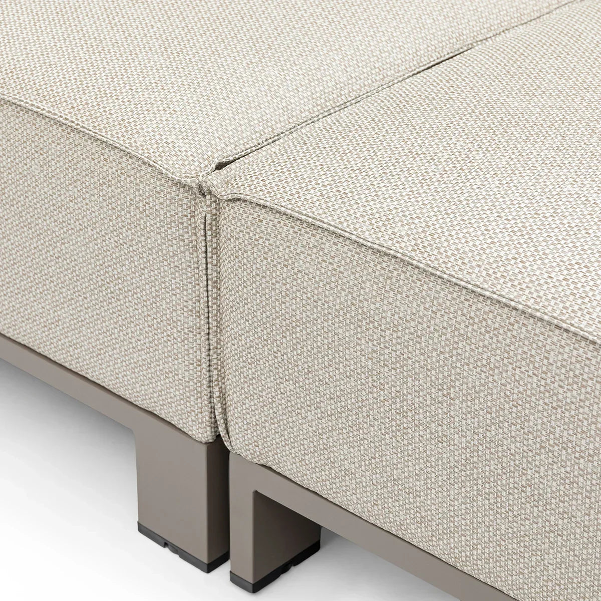 Close up of beige fabric sofa seat cushions with textured upholstery and metal legs