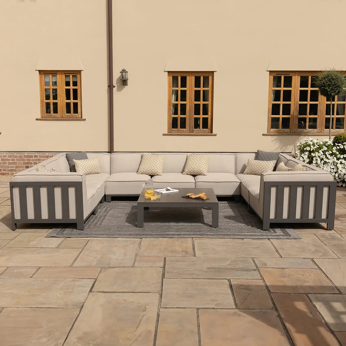 Grey outdoor corner sofa set with cushions and matching coffee table on patio