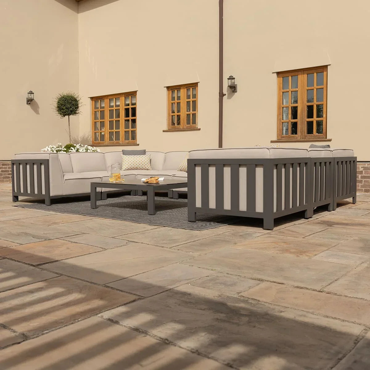 Grey outdoor corner sofa set with low coffee table on patio