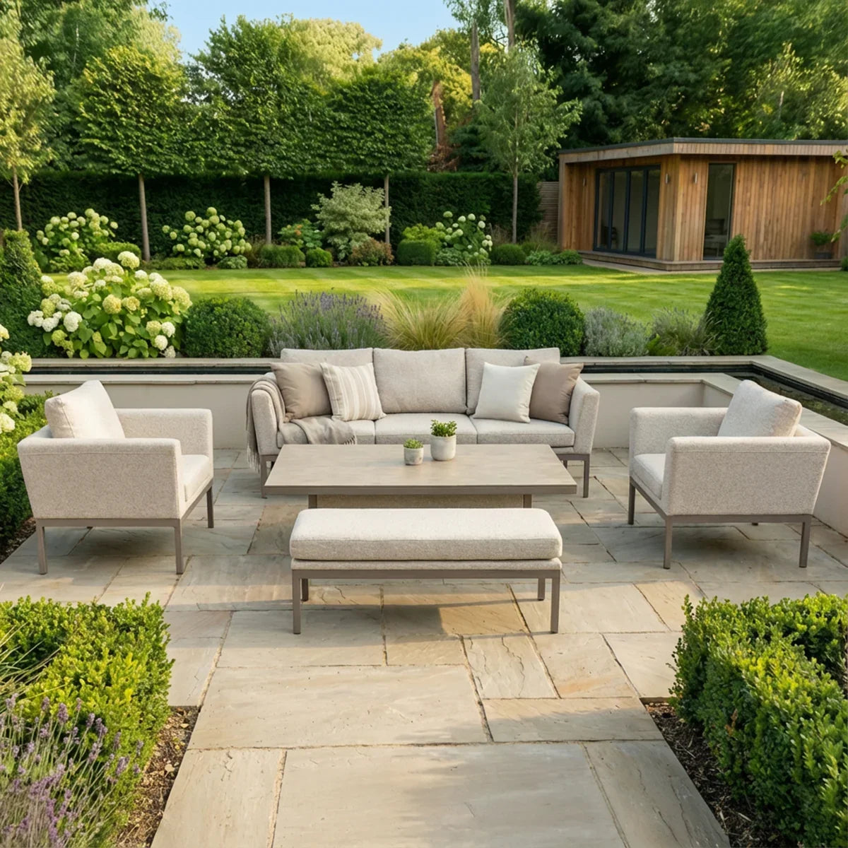Beige outdoor garden furniture set with sofa, armchairs, and table on stone patio