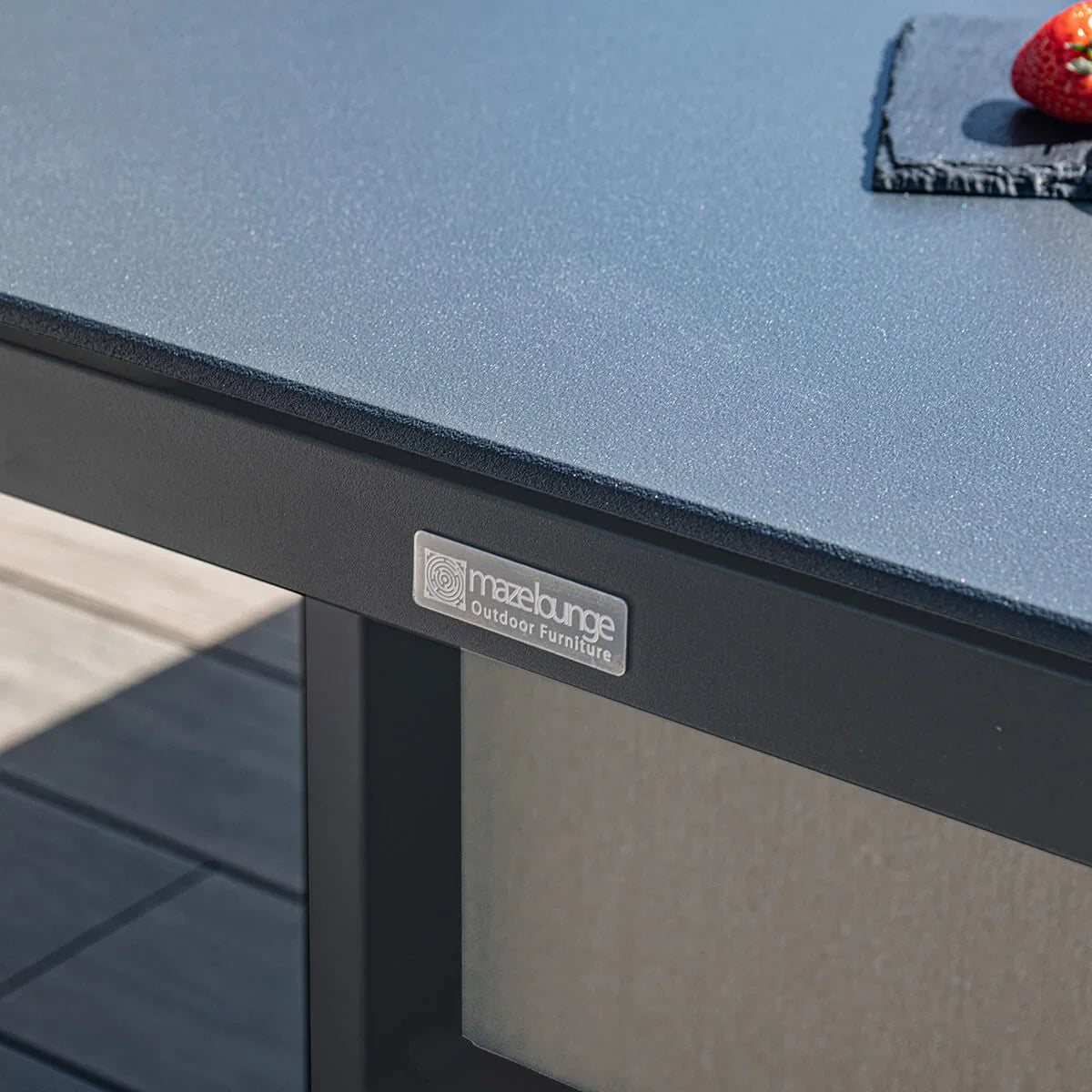 Grey outdoor furniture table with metal frame and close-up of textured top surface
