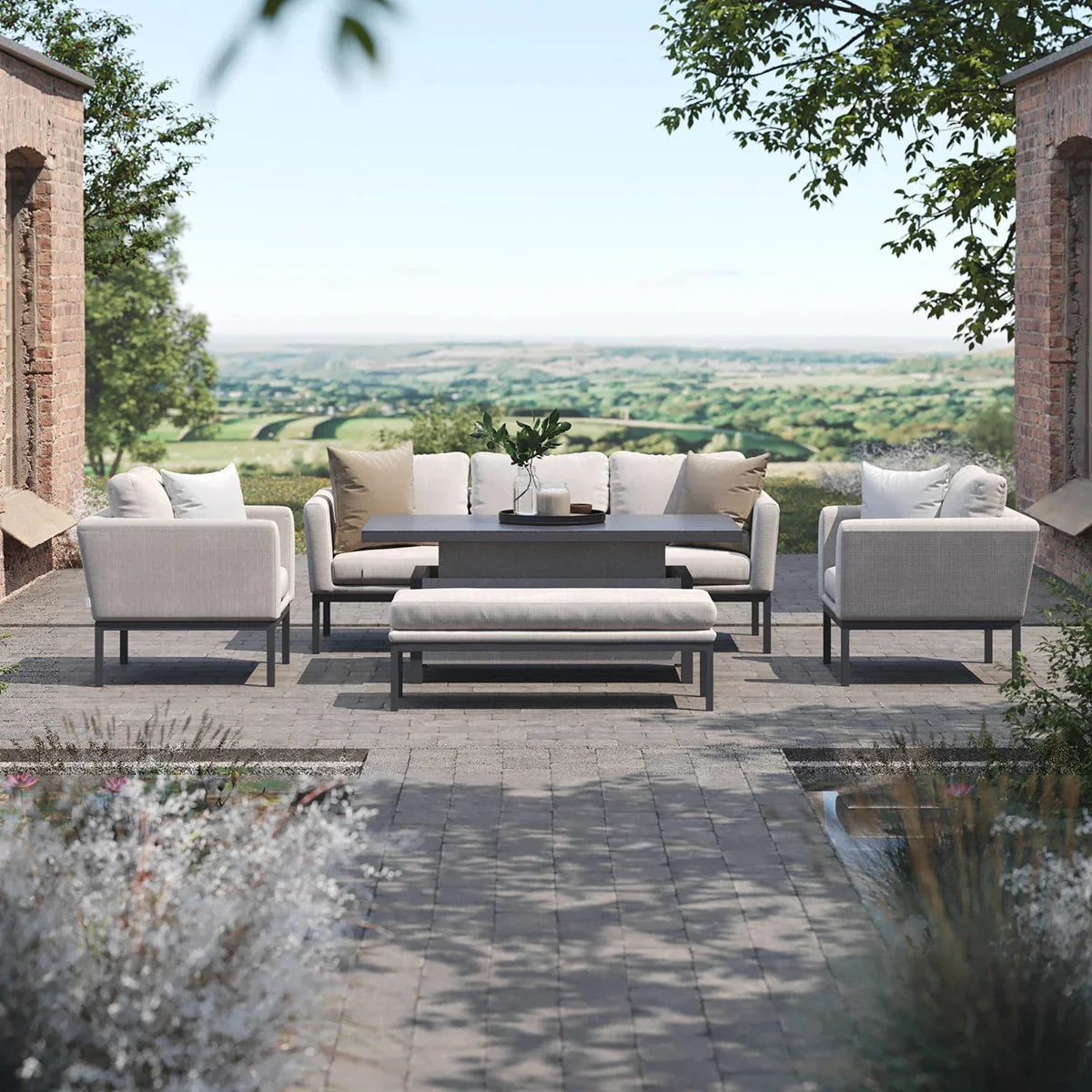 Modern outdoor sofa set with cream cushions, slate table and bench on a stone patio