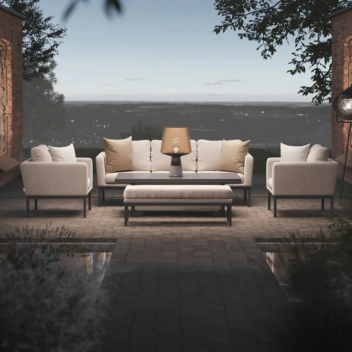 Beige outdoor sofa set with matching armchairs, coffee table and bench on brick patio